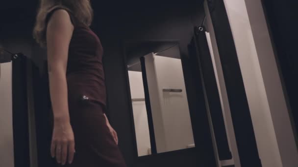 Ragazza attraente in un negozio di moda provare un vestito — Video Stock