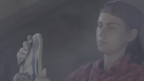 Une fille dans l'atelier polie avec planche à roulettes en papier de verre — Video