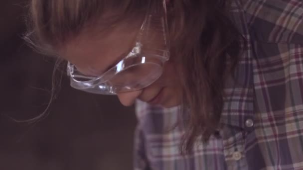 La chica en el trabajo en un taller de carpintería, con una cepilladora de mano. Primer plano — Vídeo de stock