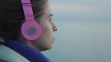 Kulaklık kız onu vintage kamera deniz günbatımı bir resim çeker