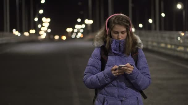 La chica del smartphone está en la ciudad por la noche, hablando en las redes sociales — Vídeos de Stock