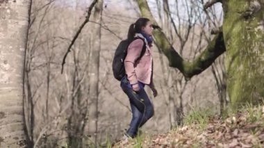 Sırt çantası olan kız yolcu ormanda seyahat ediyor