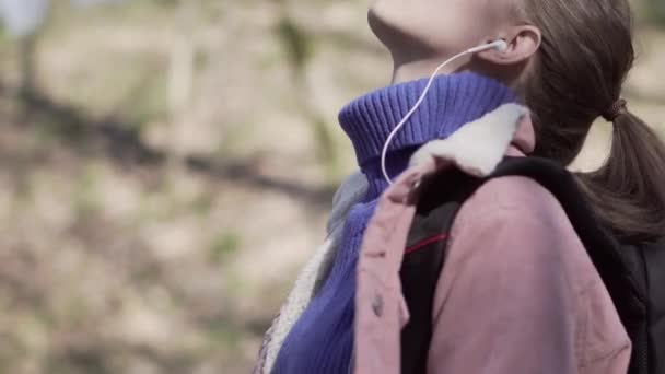 Девушка с рюкзаком гуляет по лесу — стоковое видео