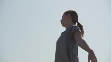 Spor kız deniz kıyısında germe yapıyor