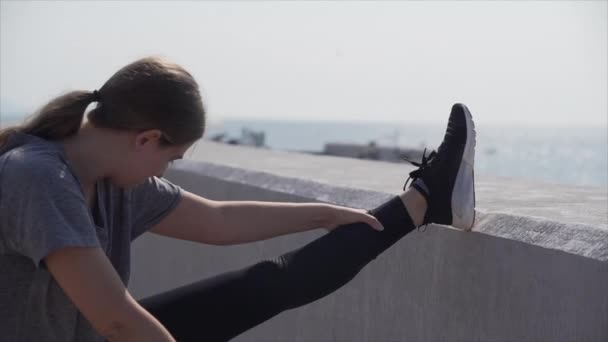 Sport dziewczyna robi rozciąganie na brzegu morza — Wideo stockowe