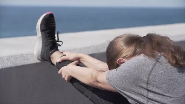 Ragazza sportiva che fa stretching sulla riva del mare — Video Stock