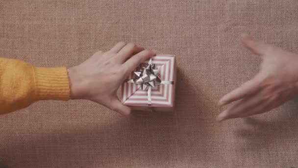 Högst upp. Kvinnliga och manliga händer ger varandra presenter. Linne bakgrund — Stockvideo