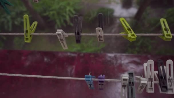 Lluvia fuerte, tendedero con pinzas de ropa. Vista desde la ventana — Vídeos de Stock