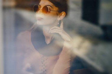 Esmer kız restoranda telefon kullanıyor.