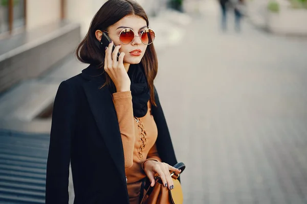 Stilvolles Mädchen, das mit dem Handy durch die Stadt läuft — Stockfoto