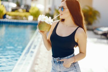 Kız hindistan cevizinden taze meyve suyu içiyor.