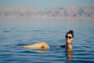 Esmer kız ölü denizde yüzüyor.