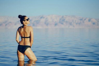 Esmer kız ölü denizde yüzüyor.