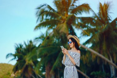 Kız telefonunu kullanarak plaj boyunca uyanma