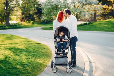 güneşli bir parkta sevimli aile