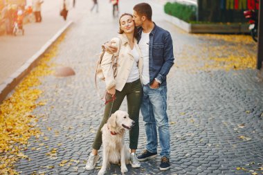 Çiftler güneşli bir sonbahar gününde köpeklerini gezdirirler.