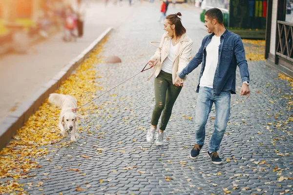 Ζευγάρι περπάτημα το σκυλί τους σε μια ηλιόλουστη μέρα του φθινοπώρου — Φωτογραφία Αρχείου