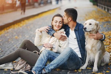 Çiftler güneşli bir sonbahar gününde köpeklerini gezdirirler.
