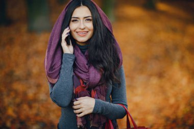 esmer kız parkta telefon kullanarak