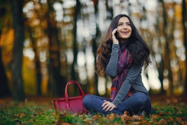 esmer kız parkta telefon kullanarak