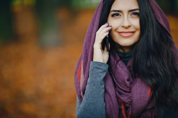 Brünette mädchen using phone während im park — Stockfoto