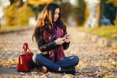 esmer kız parkta telefon kullanarak