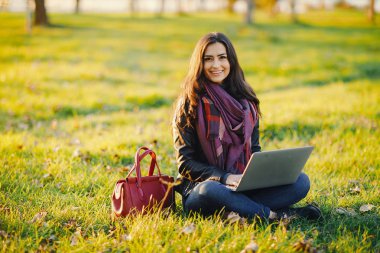 esmer kız parkta onu laptop üzerinde çalışıyor