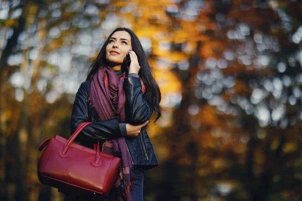 Brunette fille à l'aide de téléphone tandis que dans le parc — Photo