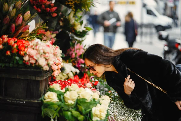 Chica se detuvo a oler las flores en un mercado en París — Foto de Stock