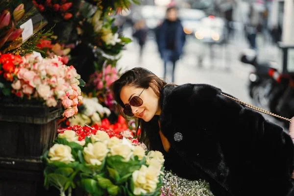 Chica se detuvo a oler las flores en un mercado en París — Foto de Stock