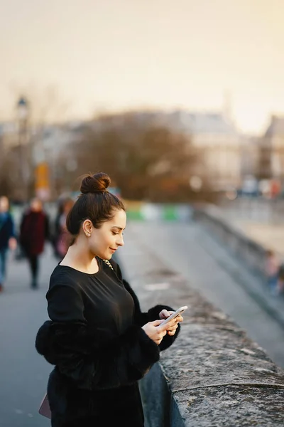 Kobieta za pomocą jej telefon komórkowy podczas spaceru przez Paryż — Zdjęcie stockowe