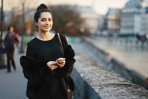 Femme utilisant son téléphone portable tout en marchant à travers Paris — Photo