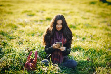 esmer kız parkta telefon kullanarak