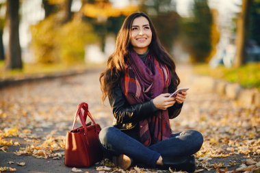 esmer kız parkta telefon kullanarak