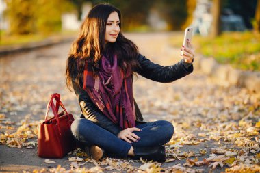 esmer kız parkta telefon kullanarak
