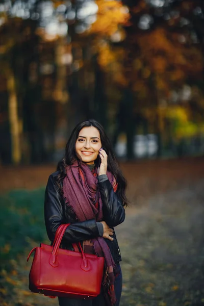 Brunette fille à l'aide de téléphone tandis que dans le parc — Photo