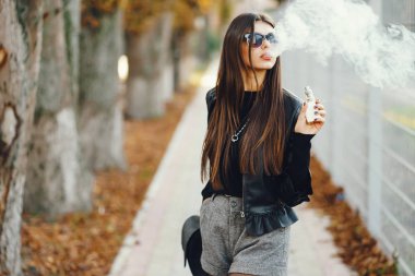 Şık bir kız e-sigara içiyor.