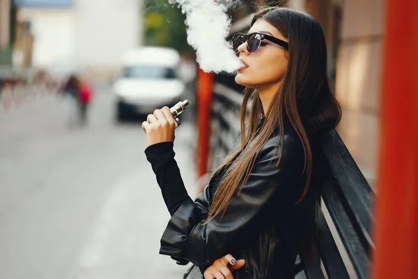 Stylowa dziewczyna palenie e-papierosa — Zdjęcie stockowe