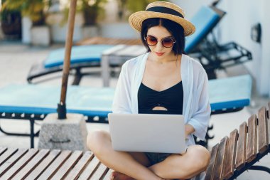 Havuz kenarında çalışan esmer kız.