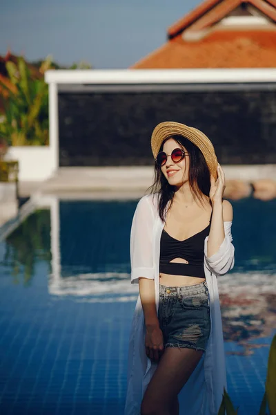 Menina morena relaxante na piscina — Fotografia de Stock