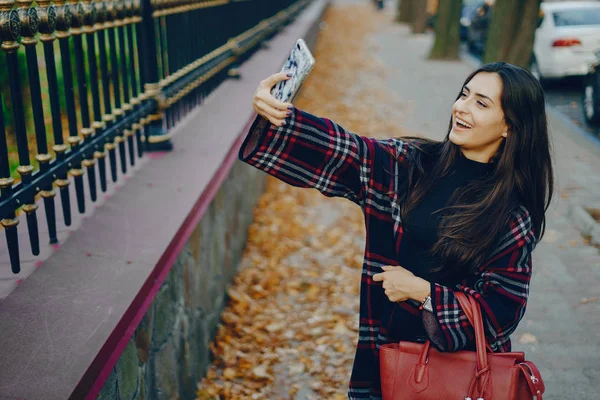 Dziewczyna za pomocą jej telefon komórkowy podczas spaceru po parku — Zdjęcie stockowe