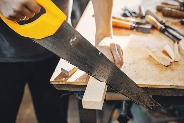 The carpenter works with a tree
