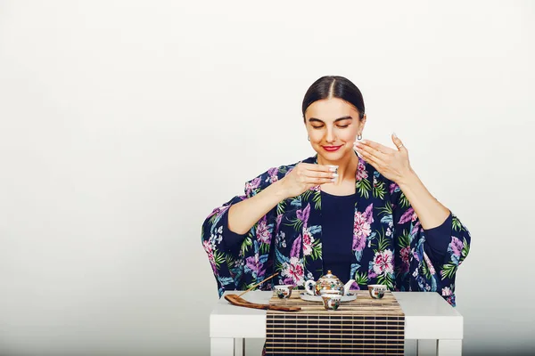 Красивая девушка пьет чай в студии — стоковое фото