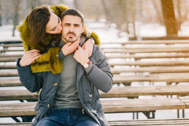 Güneşli bir kış gününde parkta yürüyen mutlu çift.