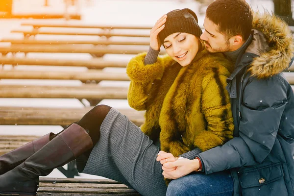 Güneşli bir kış gününde parkta yürüyen mutlu çift.