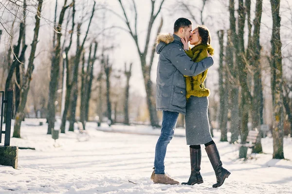 Lyckliga par promenader genom parken på en solig vinterdag — Stockfoto