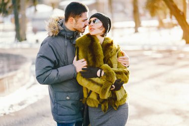 Güneşli bir kış gününde parkta yürüyen mutlu çift.