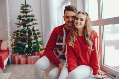 Noel ağacının yanında oturan sevimli bir aile.