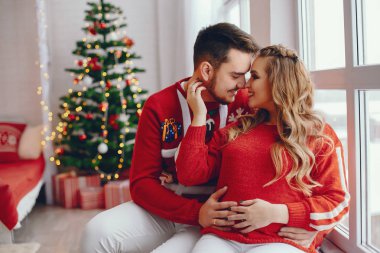 Noel ağacının yanında oturan sevimli bir aile.