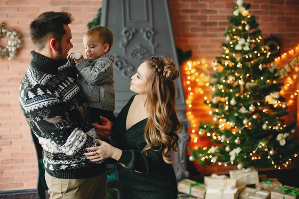 Linda familia sentada cerca del árbol de Navidad — Foto de Stock